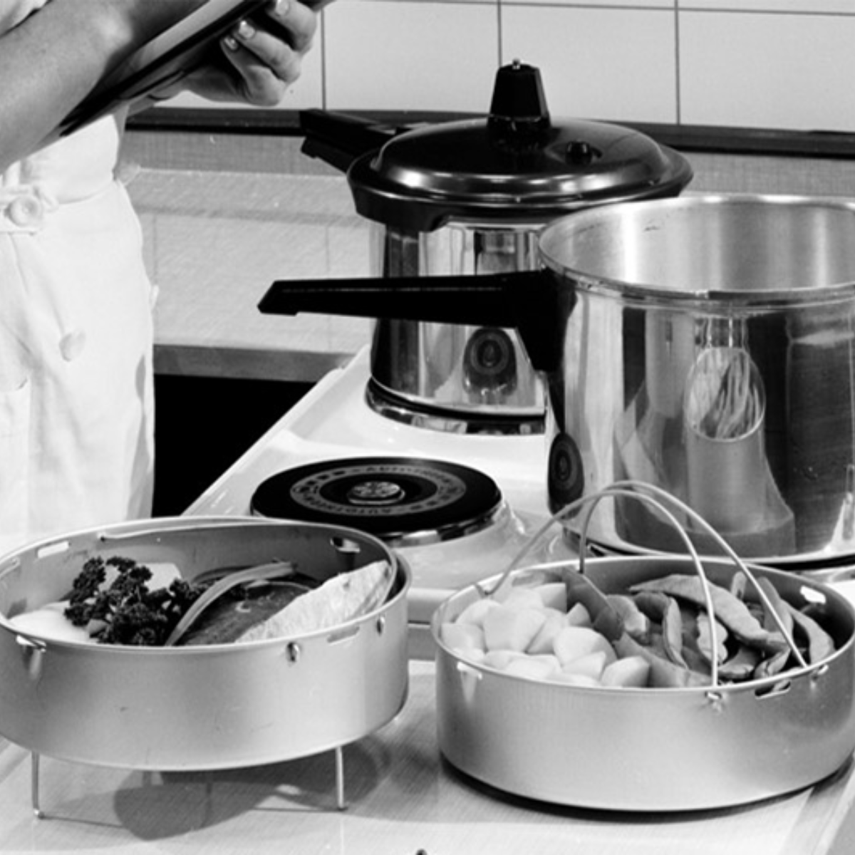 Ein Koch bereitet frische Zutaten neben einem Fissler-Edelstahltopf und Schnellkochtopf zu und demonstriert damit deutsche Präzision in der Küche.